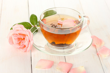 cup of tea with rose on white wooden table