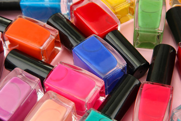 Group of bright nail polishes, on pink background