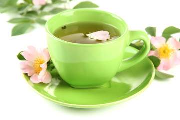 Cup of herbal tea with hip rose flowers, isolated on white