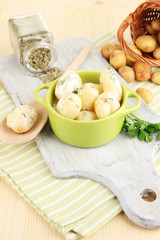 Tender young potatoes with sour cream and herbs in pan