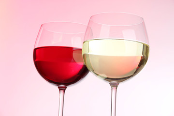Glasses of wine on light pink tone