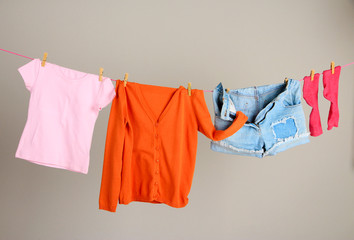 Laundry line with clothes on wall background