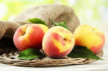 Ripe sweet peaches on wooden table in garden, close up