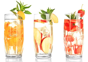 Glasses of fruit drinks with ice cubes isolated on white