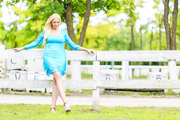 Young blond woman by the fence