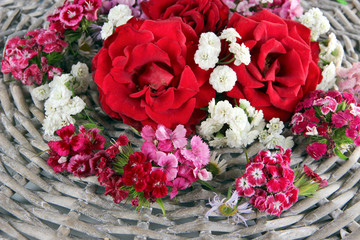 Rosie and wildflowers on wicker wooden background