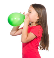 Little girl is inflating green balloon
