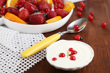 Useful fruit salad in plate on wooden table close-up