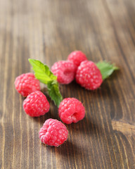 Ripe sweet raspberries on wooden background