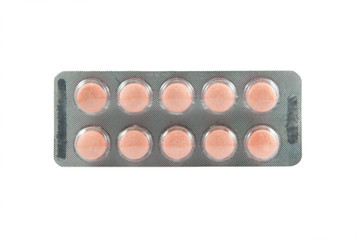 Orange medicine tablet in transparent blister pack