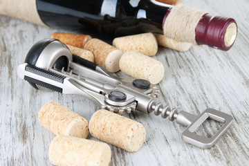 Corkscrew with wine corks and bottle of wine