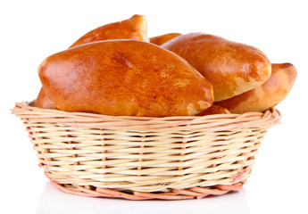 Fresh baked pasties in wicker basket, isolated on white
