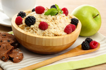 tasty oatmeal with berriesand cup of tea, on wooden table