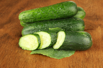 Tasty green cucumbers on wooden background