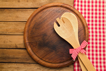 Bread board with spoons on wooden background with tablecloth