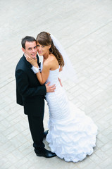 Naklejka premium happy wedding couple standing and embracing