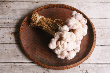 Garlic in the threshing basket on wooden table