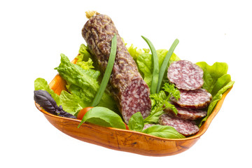Ripe salami with salad, basil, onion and tomato
