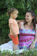 Beautiful pregnant woman talking with a young daughter.