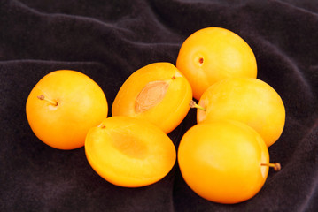 ripe yellow plums on a blue background.