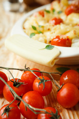 tomatoes branch on a background of penne pasta