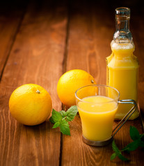 Orange and orange juice on a wooden background