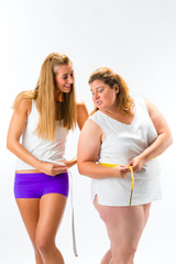 Dünne und dicke Frau messen Taillenumfang mit Maßband