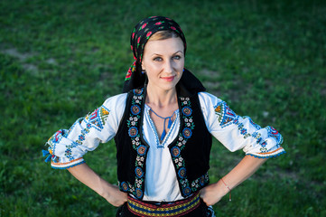 Young beautiful singer posing in traditional costume, romanian f