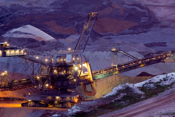 A back-filling machine in an open coal mine at night
