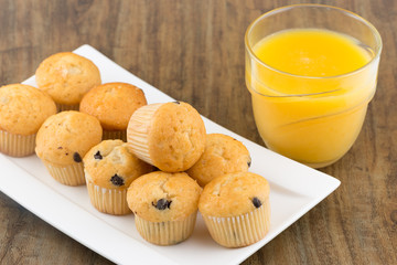 fresh chocolate chip muffins with a glass of orange juice