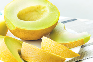 Sliced yellow melon on white plate