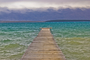 Rough sea and foggy mountain wooden boardwalk