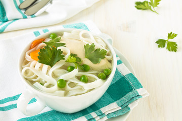 Chicken and rice  noodle soup  with peas