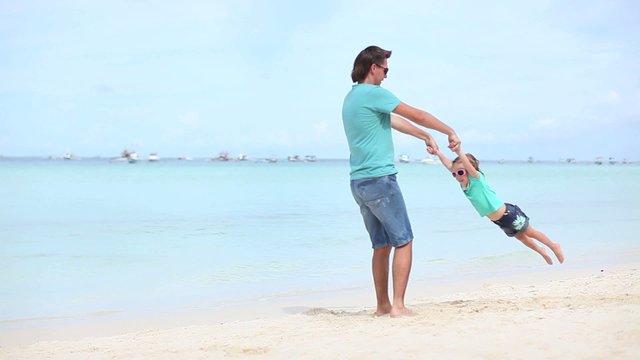 Young father and his little daughter on exotic white sand beach