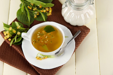 Cup of tea with linden on napkin on   wooden table