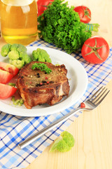 Piece of fried meat on plate on wooden table close-up