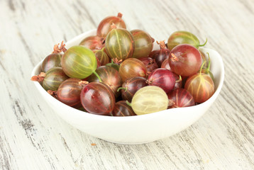 Fresh gooseberries in bowl on table close-up