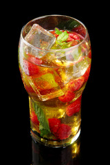 Iced tea with raspberries and mint on black background
