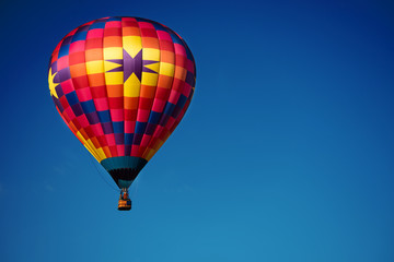 Brightly colored hot air balloon with a sky blue background