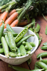 Pea pods in a bowl with carrots