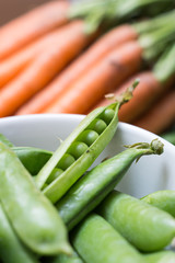 Pea pods in a bowl with carrots