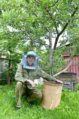The young beekeeper from swarms to it on an apiary