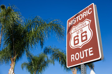 Historic route 66 highway sign with palm tree and a blue sky