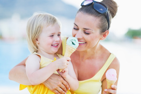 Smiling baby giving mother ice cream