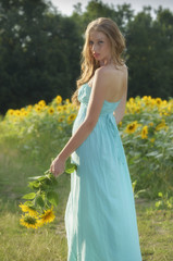 Naklejka na ściany i meble beauty young woman in sunflower field