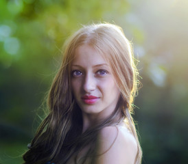 Portrait of young attractive woman at summer green park.