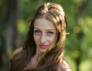 Fototapeta premium Portrait of young attractive woman at summer green park.