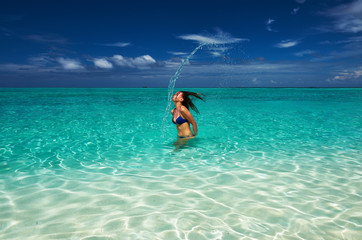 Woman splashing water with hair in the ocean