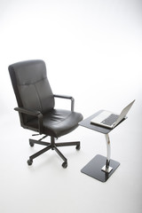 Fototapeta premium Black office chair and laptop on glass desk
