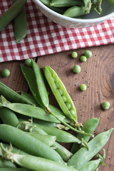 Pea pods in a bowl on wooden Table
